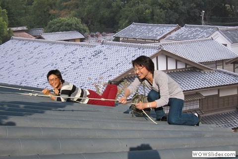 two women climb rooftop